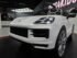 Child driving white Porsche Cayenne electric ride-on car