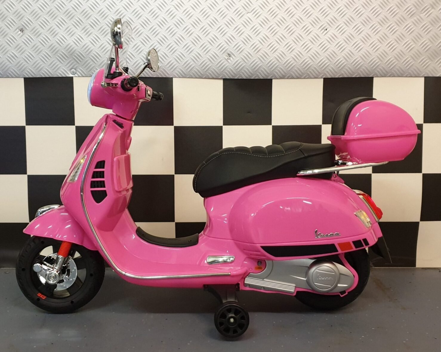 Pink Vespa electric scooter for children side view showing leather seat